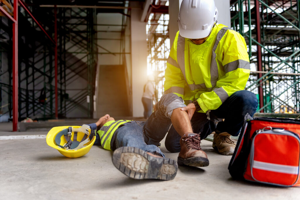 A construction worker helps his injured coworker following a workplace accident