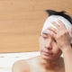 man with head injury from cat accident holding bandage on head