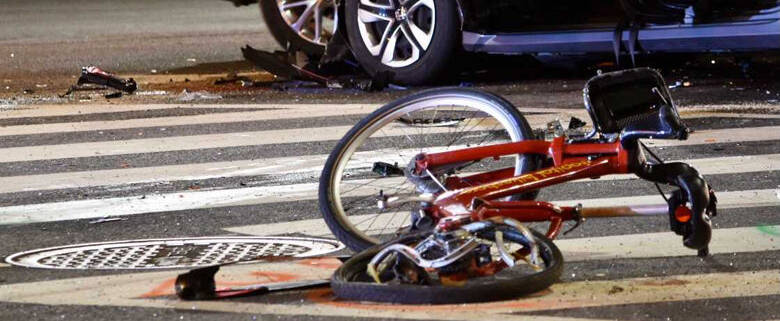 A bicycle lies crumpled in the street after being hit by a car in a bicycle accident